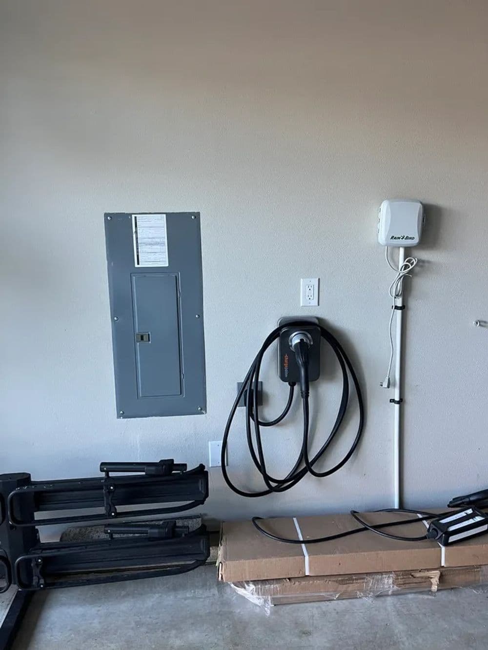 Electric vehicle charging station setup in a modern garage with electrical panel.
