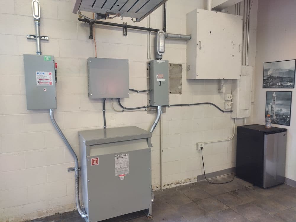 Wall-mounted electrical panels and equipment in a commercial space.