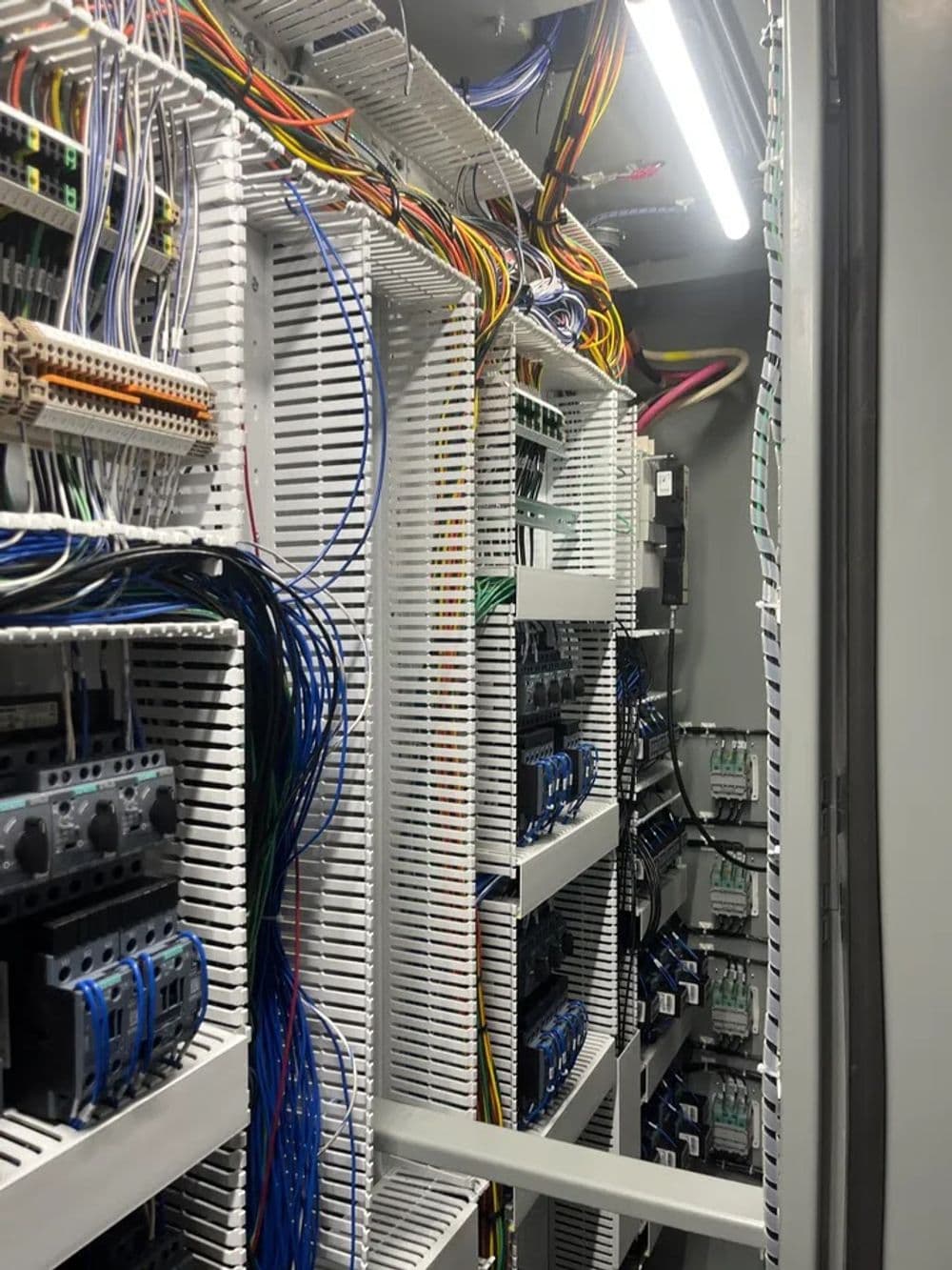 Close-up of a data center rack with organized wiring and electrical components.
