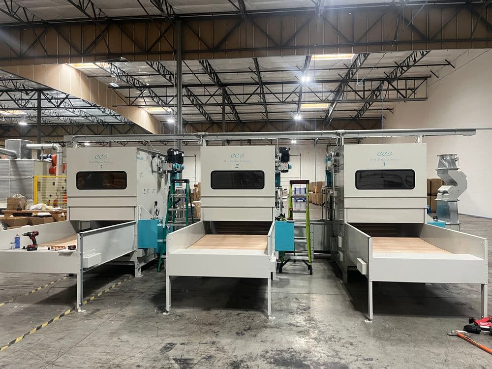 Three industrial machines in a warehouse, designed for processing materials efficiently.