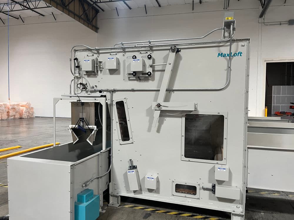 Industrial Max Loft machine with control panel, situated in a spacious warehouse environment.